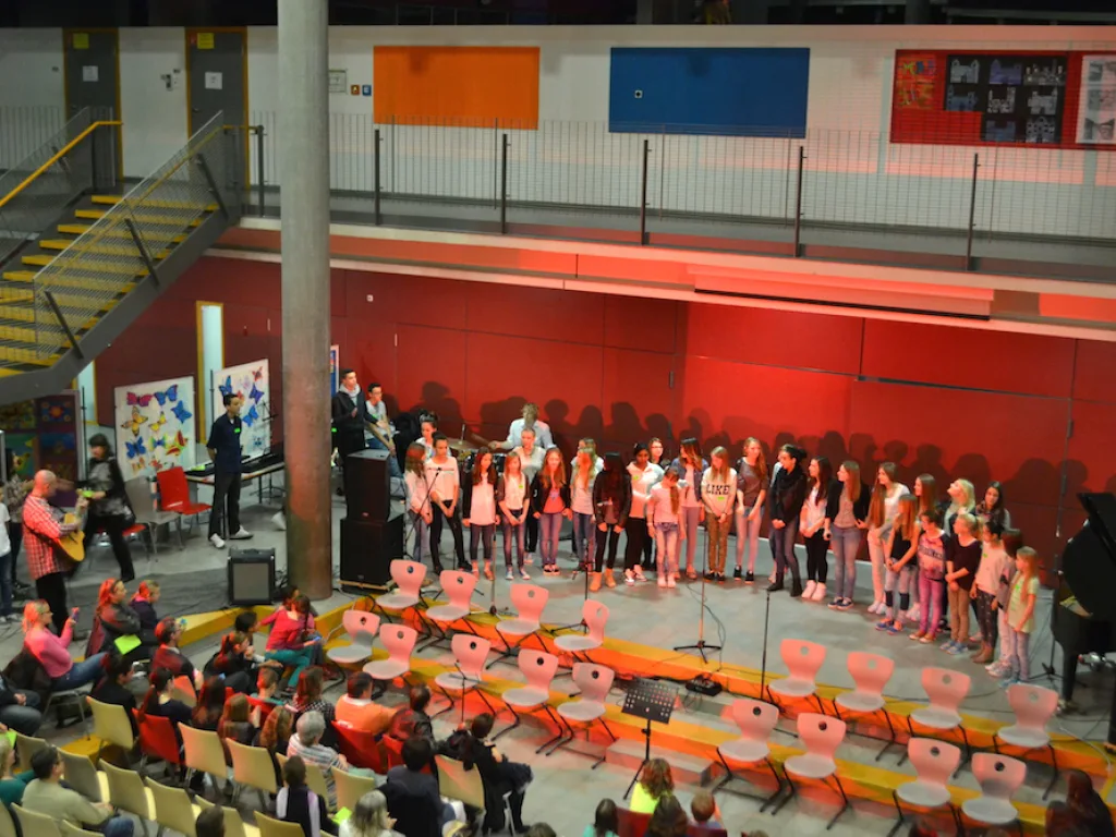 Chorgruppe singt vor der roten Wand.
